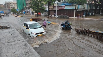 Car drive through a waterlogged road amidst heavy rainfall from Cyclone Tauktae in Mumbai. (Image: News18)
