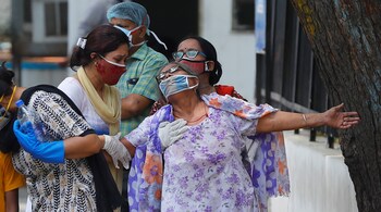 A woman mourns after seeing the body of her son who died due to the coronavirus disease (COVID-19), outside a mortuary of a COVID-19 hospital in New Delhi, India, May 12, 2021. (PC-REUTERS/Adnan Abidi)