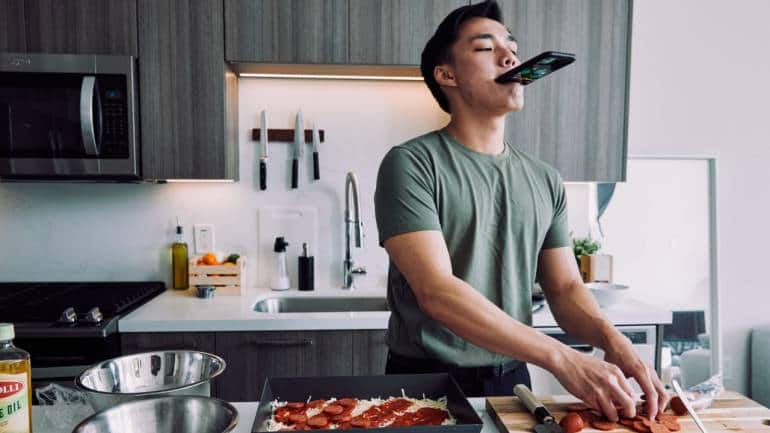 Newton Nguyen films a cooking video for TikTok at his home in Los Angeles, May 17, 2021. Nguyen is one of the best-known food creators on TikTok, with almost seven million followers. (Adam Amengual/The New York Times)