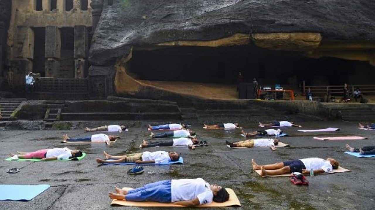 People take part in a yoga session at the Kanheri Caves near Mumbai, India (Image: Indranil Mukherjee/AFP)