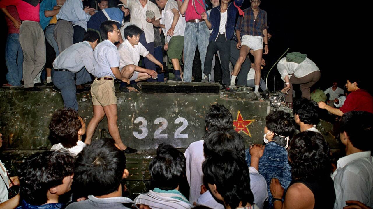 In this early June 4, 1989, file photo, civilians with rocks stand on a military armored vehicle near Chang'an Boulevard in Beijing as violence escalated between pro-democracy protesters and Chinese troops, leaving hundreds dead overnight. (AP Photo/Jeff Widener, File)