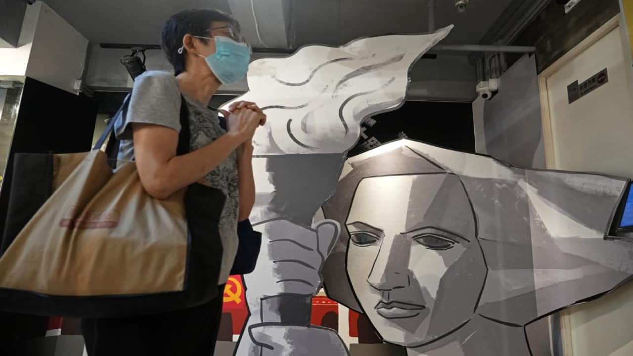 A visitor stands next to a cutout of a Goddess of Democracy at the &quot;June 4 Memorial Museum&quot; run by pro-democracy activists in Hong Kong on Sunday, May 30, 2021. 