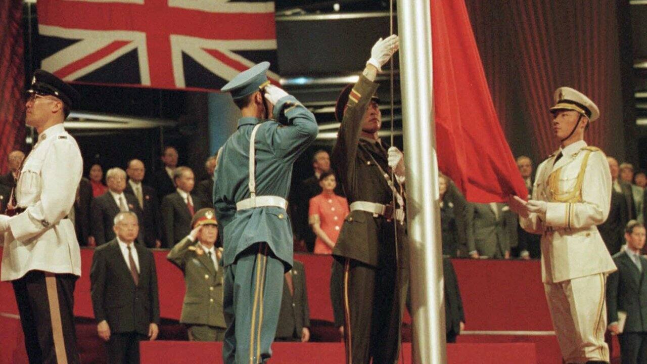In this June 30, 1997, file photo, members of the combined Chinese Armed Forces color guard raise the Chinese flag at the Hong Kong convention center marking the moment Hong Kong reverted to Chinese rule. (Kimimasa Mayama/Pool Photo via AP, File)
