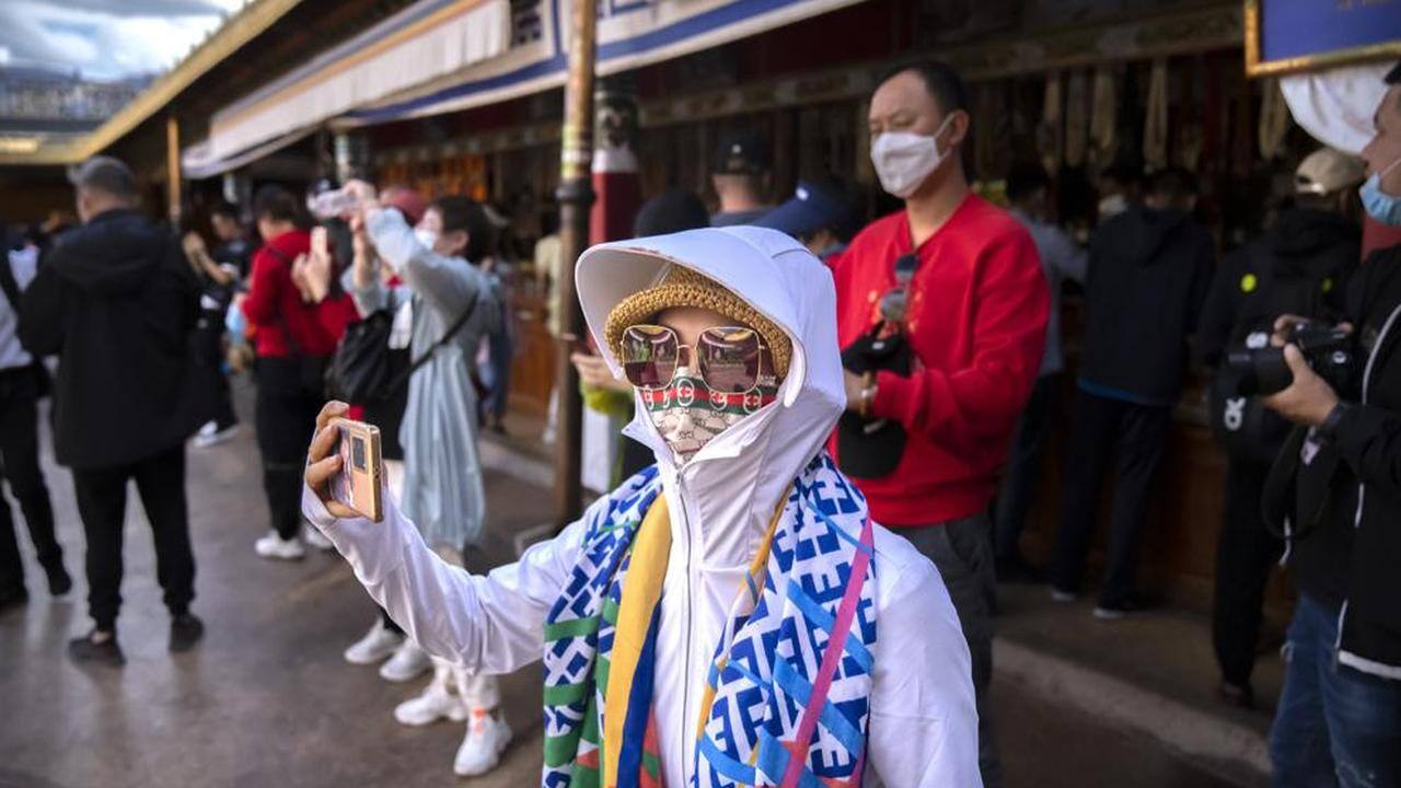 A tourist takes a smartphone photo at the Jokhang Temple in Lhasa in western China's Tibet Autonomous Region, Tuesday, June 1, 2021. Tourism is booming in Tibet as more Chinese travel in-country because of the coronavirus pandemic, posing risks to the region's fragile environment and historic sites. (AP Photo/Mark Schiefelbein) A tourist takes a smartphone photo at the Jokhang Temple in Lhasa in western China's Tibet Autonomous Region, Tuesday, June 1, 2021. Tourism is booming in Tibet as more Chinese travel in-country because of the coronavirus pandemic, posing risks to the region's fragile environment and historic sites. (AP Photo/Mark Schiefelbein)