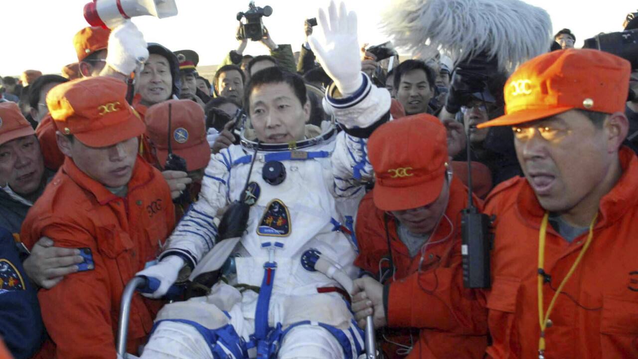 In this Oct. 16, 2003, file photo, crew carry the first Chinese astronaut Yang Liwei, center, after landing on the Inner Mongolian grasslands of northern China. Beijing's mission control declared the country's landmark debut flight &quot;a success.&quot; (Xinhua via AP, File)