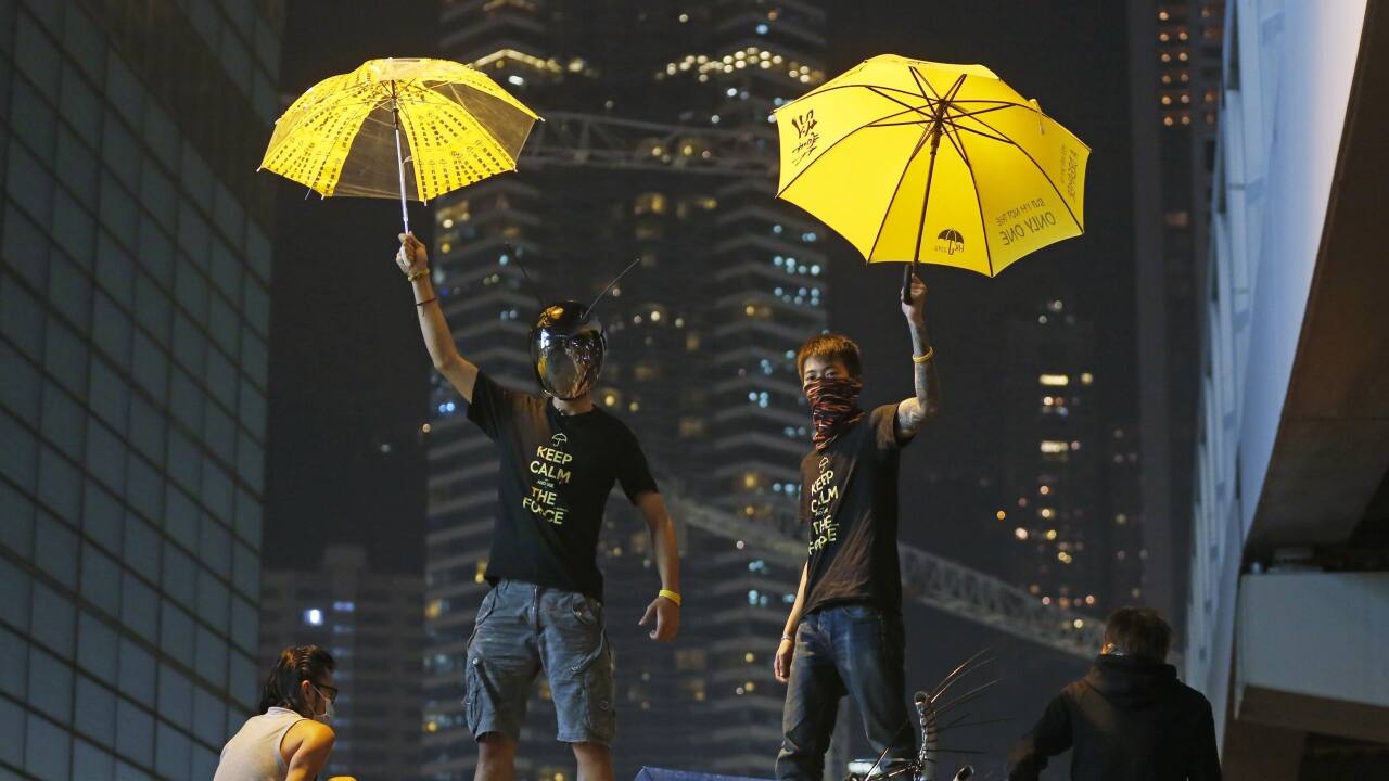 In this Dec. 10, 2014, file photo, protesters stand on a barricade at the occupied area outside government headquarters in Hong Kong. Hong Kong's dwindling number of pro-democracy protesters vowed Wednesday to stay until the last minute before authorities clear them off a highway where they've been camped out for more than two months. (AP Photo/Kin Cheung, File)