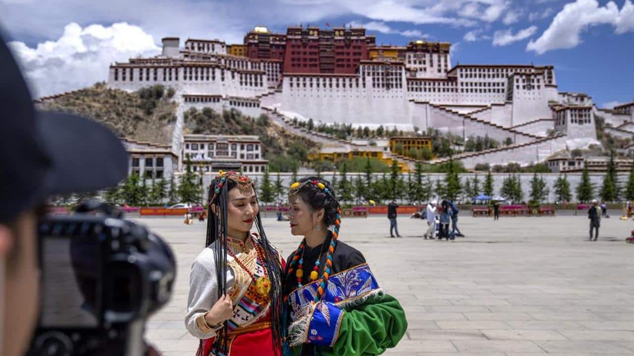 Chinese tourists in Tibetan dress pose for a photo at a square near the Potala Palace in Lhasa in western China's Tibet Autonomous Region, Tuesday, June 1, 2021. Tourism is booming in Tibet as more Chinese travel in-country because of the coronavirus pandemic, posing risks to the region's fragile environment and historic sites. (AP Photo/Mark Schiefelbein) Chinese tourists in Tibetan dress pose for a photo at a square near the Potala Palace in Lhasa in western China's Tibet Autonomous Region, Tuesday, June 1, 2021. Tourism is booming in Tibet as more Chinese travel in-country because of the coronavirus pandemic, posing risks to the region's fragile environment and historic sites. (AP Photo/Mark Schiefelbein)