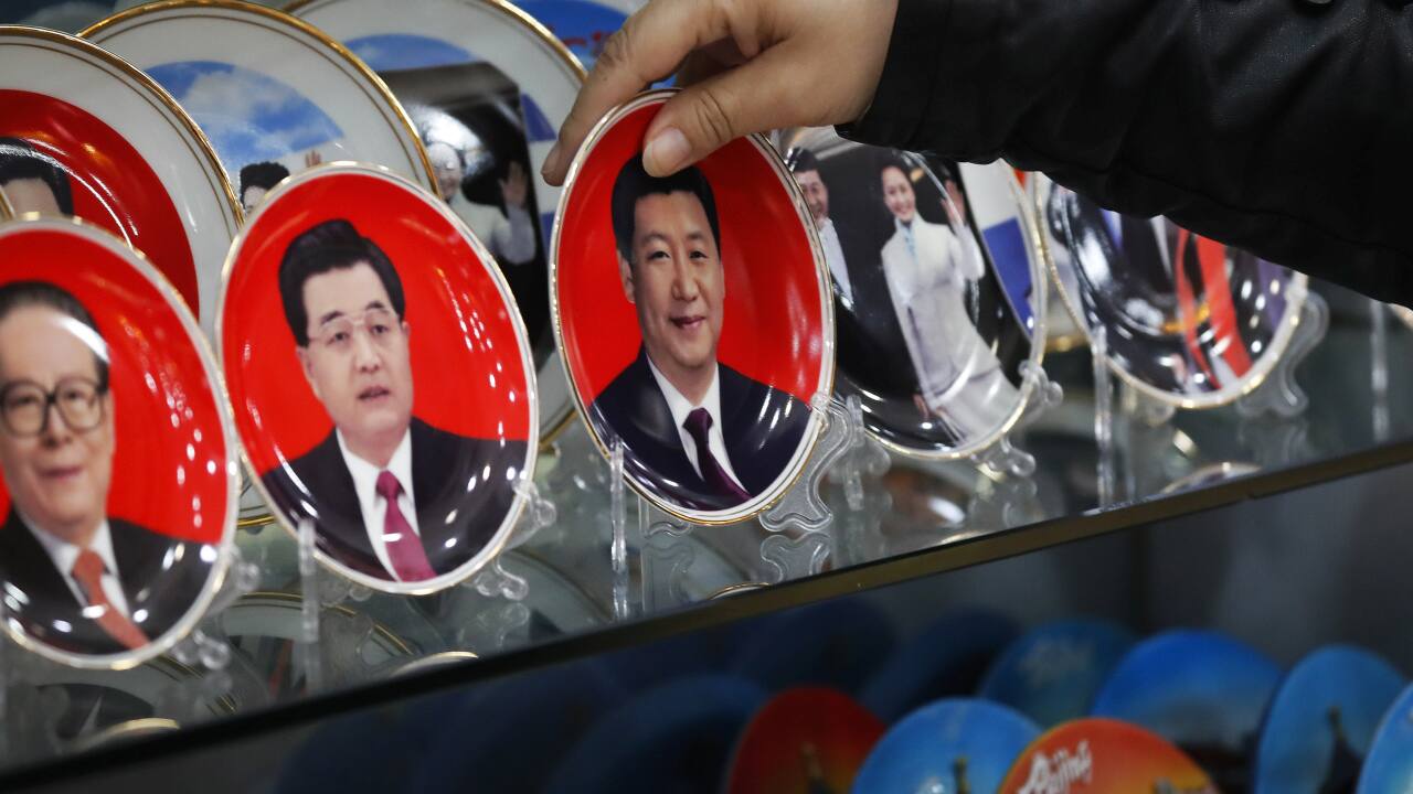 In this Oct. 27, 2016, file photo, a worker takes a porcelain plate bearing an image of Chinese President Xi Jinping for a customer which on display together with previous leaders Jiang Zemin, left, and Hu Jintao, second left, at a souvenir shop near Tiananmen Square in Beijing. (AP Photo/Andy Wong, File)