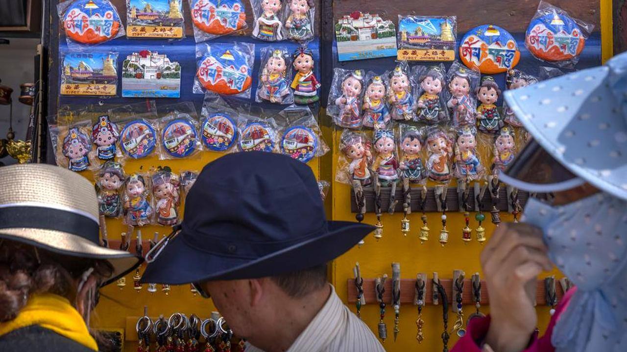 Tourists look at merchandise for sale at a souvenir shop outside of the Jokhang Temple in Lhasa in western China's Tibet Autonomous Region, Tuesday, June 1, 2021. Tourism is booming in Tibet as more Chinese travel in-country because of the coronavirus pandemic, posing risks to the region's fragile environment and historic sites. (AP Photo/Mark Schiefelbein) Tourists look at merchandise for sale at a souvenir shop outside of the Jokhang Temple in Lhasa in western China's Tibet Autonomous Region, Tuesday, June 1, 2021. Tourism is booming in Tibet as more Chinese travel in-country because of the coronavirus pandemic, posing risks to the region's fragile environment and historic sites. (AP Photo/Mark Schiefelbein)