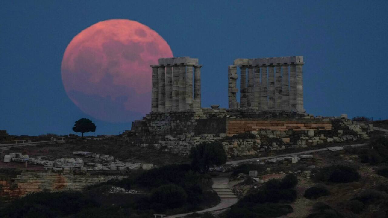 The strawberry full moon rises behind the ancient marble temple of Poseidon at Cape Sounion, about 70 Km (45 miles) south of Athens, on June 24. (Image: AP)