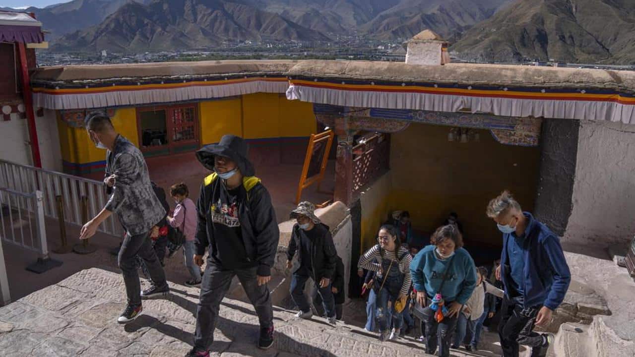 Tourists climb a flight of stairs at the Potala Palace in Lhasa in western China's Tibet Autonomous Region, Tuesday, June 1, 2021. Tourism is booming in Tibet as more Chinese travel in-country because of the coronavirus pandemic, posing risks to the region's fragile environment and historic sites. (AP Photo/Mark Schiefelbein) Tourists climb a flight of stairs at the Potala Palace in Lhasa in western China's Tibet Autonomous Region, Tuesday, June 1, 2021. Tourism is booming in Tibet as more Chinese travel in-country because of the coronavirus pandemic, posing risks to the region's fragile environment and historic sites. (AP Photo/Mark Schiefelbein)