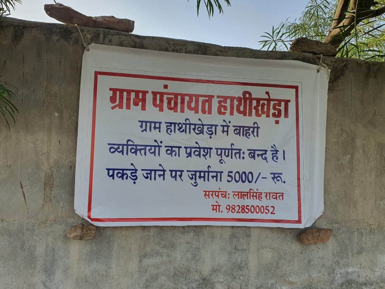 A sign warns that outsiders caught within village limits will be fined Rs 5,000 (Image: Kshitiz Gaur)