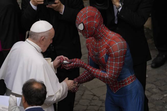 Pope Francis meets Spider-Man, who presents him with a mask, at the end of his weekly general audience with a limited number of faithful in the San Damaso Courtyard at the Vatican, Wednesday, June 23, 2021. The masked man works with sick children in hospitals. (AP Photo/Andrew Medichini)