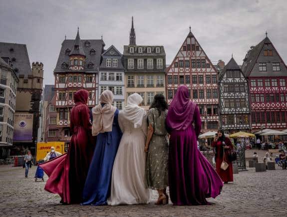 A bride, center, and her friends pose for pictures after a wedding in the town hall at Roemerberg square in Frankfurt, Germany, Friday, June 25, 2021. (AP Photo/Michael Probst)