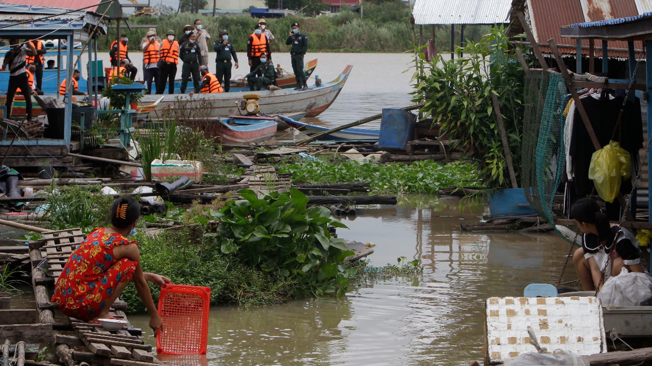 Local authorities, rear, order villagers to dismantle their floating houses along the Tonle Sap river bank near the village of Prek Pnov in Phnom Penh, Cambodia. (AP Photo/Heng Sinith)