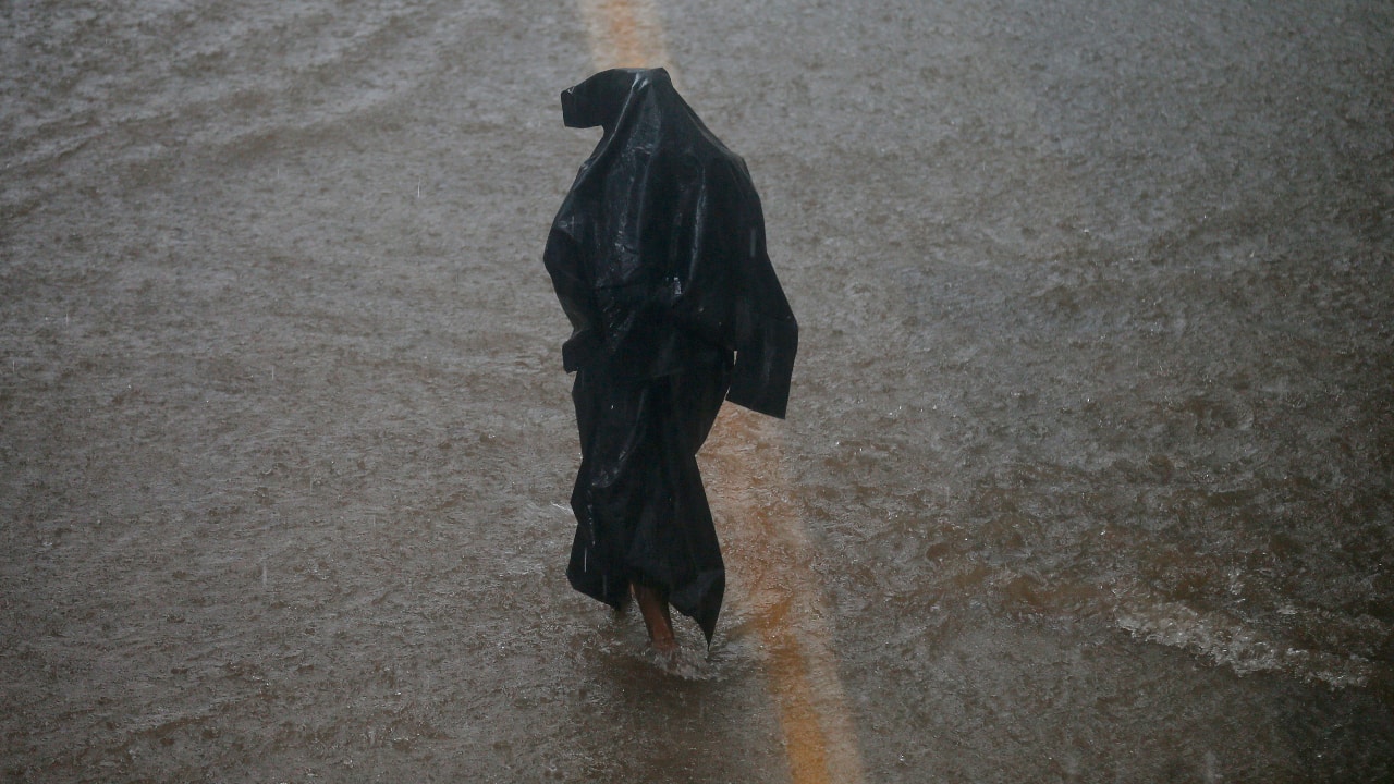 A man walks through a flooded street during heavy rains in Mumbai. (AP Photo/ Rafiq Maqbool)