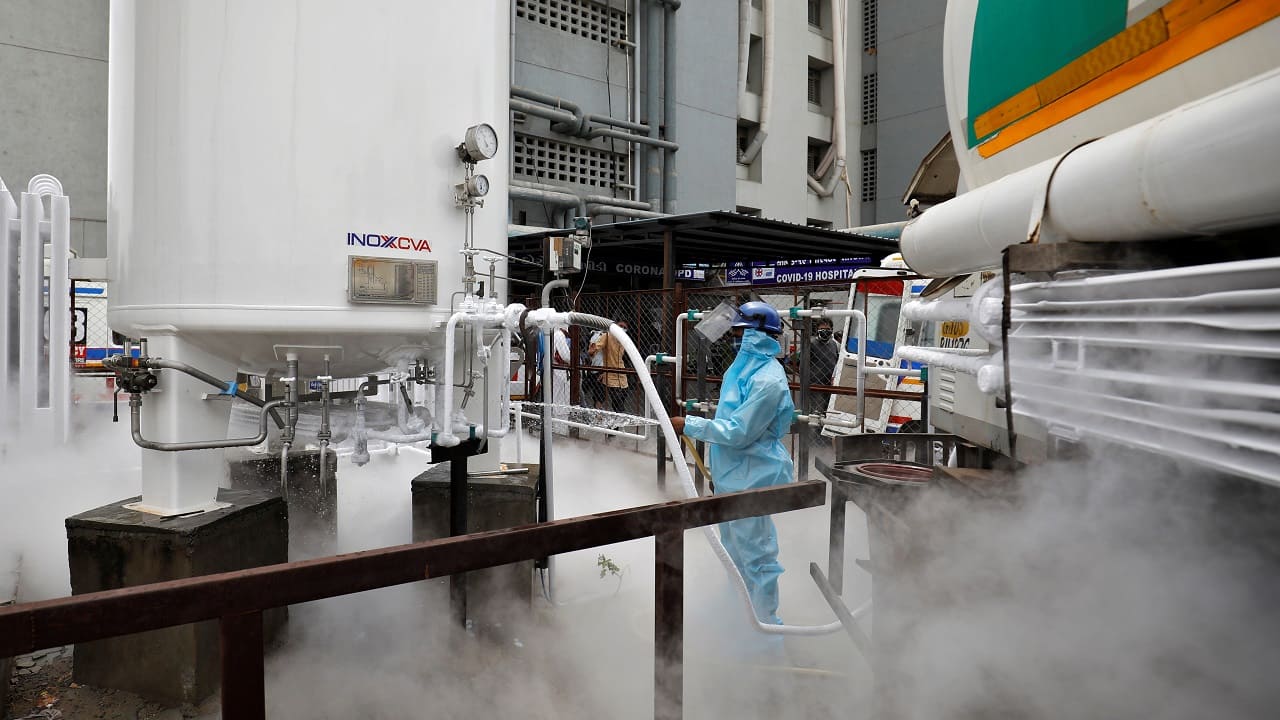 A worker stands as a tanker is filled with liquid oxygen to be transported to a COVID-19 hospital in Ahmedabad, on April 2021 (Image: Reuters/Amit Dave)