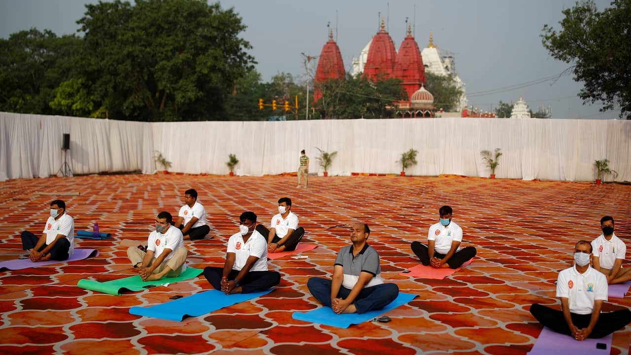 Participants, some wearing protective face masks, perform yoga during World Yoga Day in the old quarters of Delhi, India (Image: Reuters/Adnan Abidi)