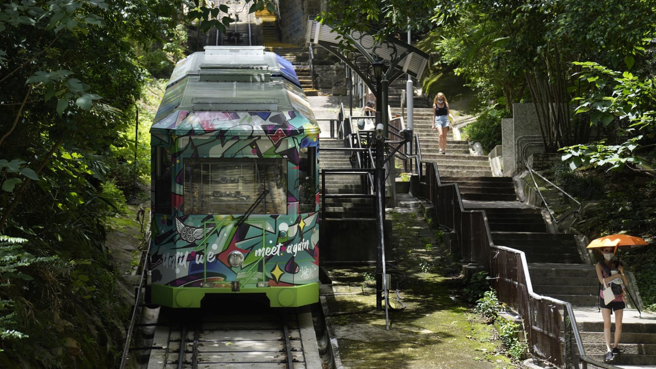 Since then, the tram has undergone several makeovers. The current fifth-generation Peak Tram, with a burgundy exterior and varnished wood interiors, began running in 1989 and carries 120 passengers. (AP Photo/Vincent Yu)