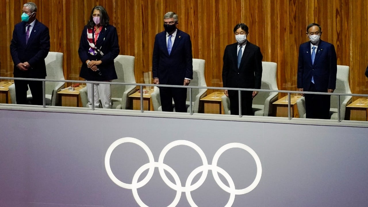 President of the International Olympic Committee Thomas Bach and others stand during the opening ceremony at the Olympic Stadium at the 2020 Summer Olympics. (Image: AP)