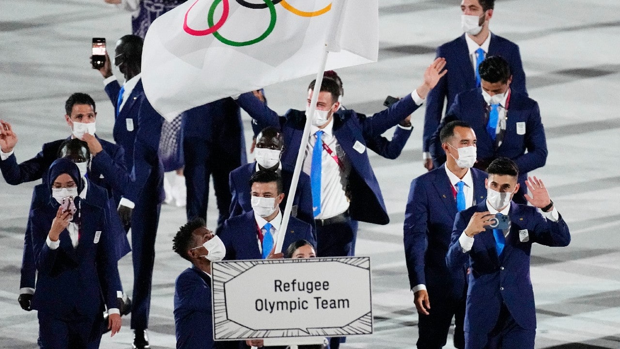 Yusra Mardini and Tachlowini Gabriyesos, of the Refugee Olympic Team, carry the Olympic flag during the opening ceremony in the Olympic Stadium at the 2020 Summer Olympics, July 23, in Tokyo, Japan. (Image: AP)