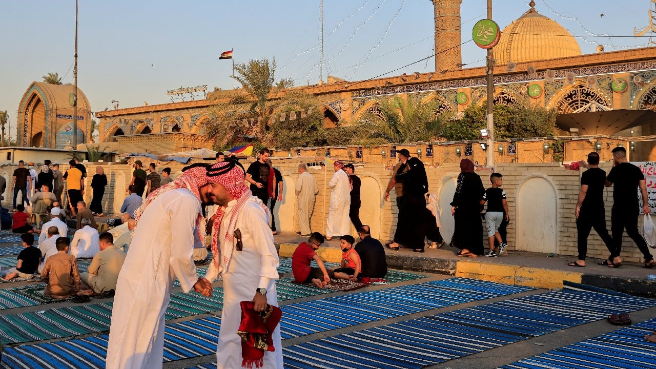 Iraqi worshippers exchange greetings after Eid al-Adha prayers on the street outside Abu Hanifa mosque in Baghdad Adhamiya district, Iraq, July 20. (Image: Reuters)