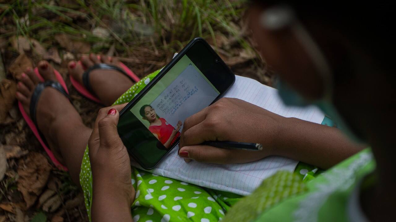 Information technology teacher Nimali Anuruddhika uses the signal to upload lessons for her students who haven't been able to go to school because of the COVID-19 pandemic. The students who also live in the village make the same climb to download online lessons sent to them by their teachers. (Image: AP)