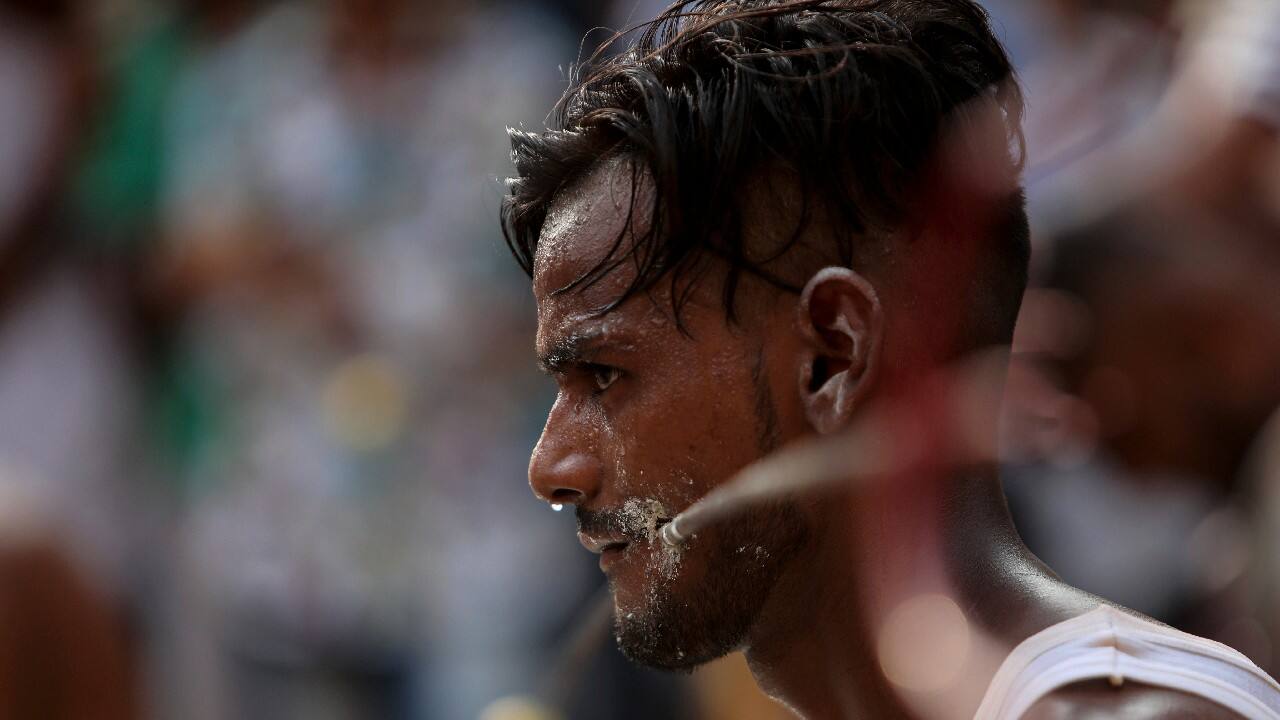 An devotee with steel tridents pierced through his cheek as part of a ritual, prepares to start off on an annual pilgrimage to the temple of Hindu goddess Sheetla Mata in Jammu, India, July 25. (Image: AP)