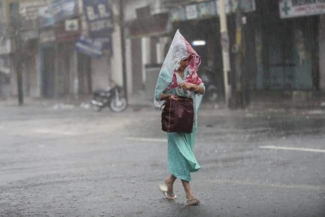 A woman walks through a street during monsoon rains Jammu, India, Monday, July 12, 2021. India’s monsoon season runs from June to September. (AP Photo/Channi Anand)