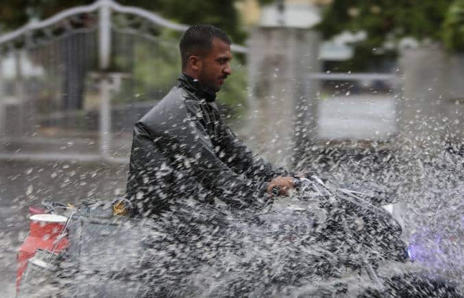 A man rides a motorcycle through a flooded street during monsoon rains Jammu, India, Monday, July 12, 2021. India’s monsoon season runs from June to September. (AP Photo/Channi Anand)