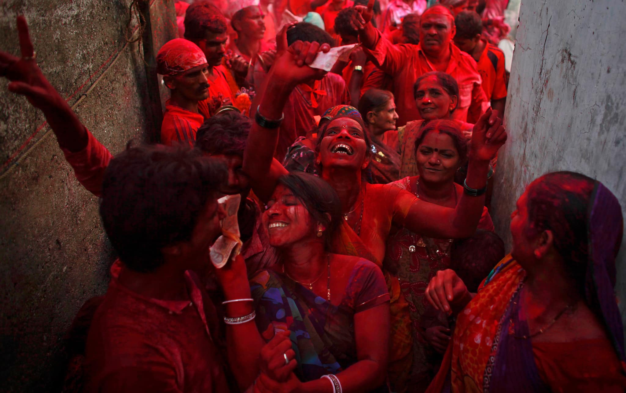Devotee with their faces covered with coloured powder dance in an alley during a procession on the ninth day of the ten-day-long Ganesh Chaturthi festival in Mumbai September 27, 2012. Ganesh idols are taken through the streets in a procession accompanied by dancing and singing and later immersed in a river or the sea symbolising a ritual seeing-off of his journey towards his abode, taking away with him the misfortunes of all mankind. REUTERS/Danish Siddiqui (INDIA - Tags: RELIGION SOCIETY TPX IMAGES OF THE DAY) - GM1E89R1PQ201