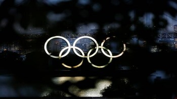 The giant Olympic rings are seen through a tree in the dusk at the waterfront area of Odaiba Marine Park, before the opening ceremony of the 2020 Tokyo Olympic Games that have been postponed to 2021 due to the coronavirus disease (COVID-19) outbreak, in Tokyo, Japan July 8, 2021. REUTERS/Issei Kato - RC2AGO9L0937