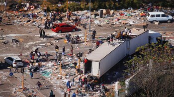 People loot an area near a burning warehouse after violence erupted in Durban, July 14, 2021. (Image: Reuters)