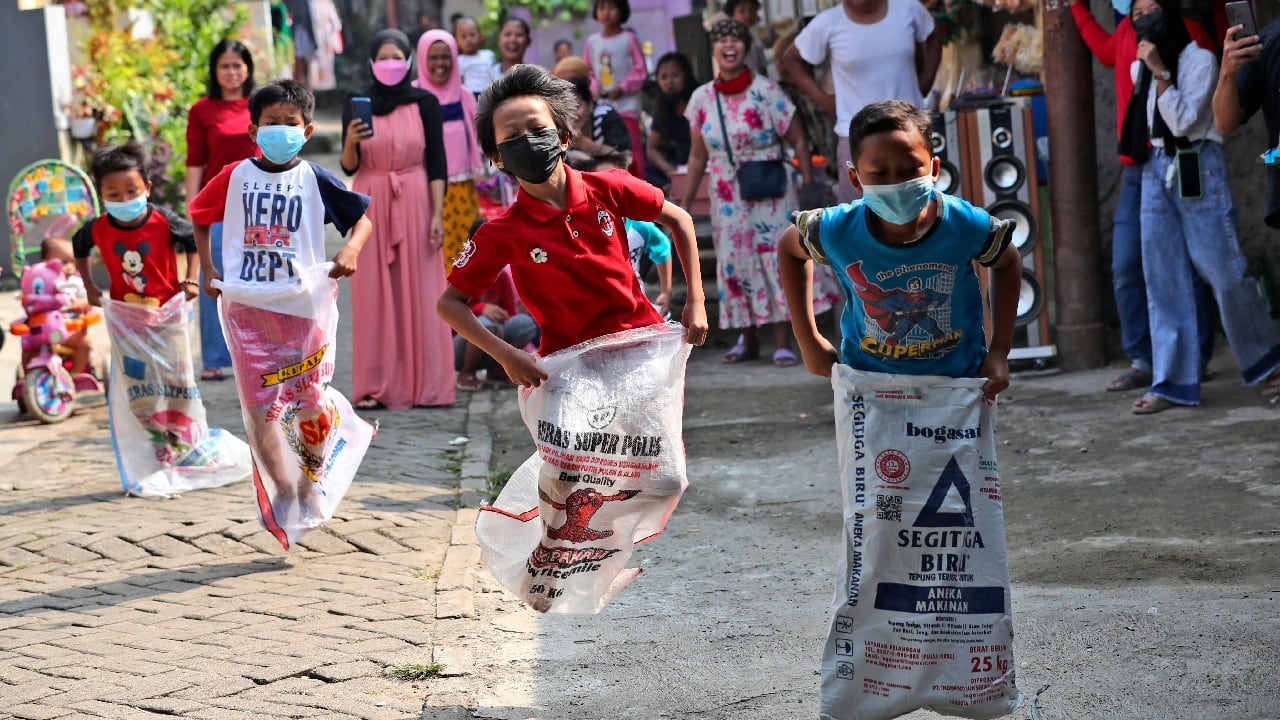 Children, wearing masks to curb the spread of coronavirus outbreak, take part in a sack race competition during an Independence Day celebrations in Jakarta, Indonesia, August 17. Indonesia is celebrating its 76th anniversary of independence from Dutch colonial rule. (Image: AP)