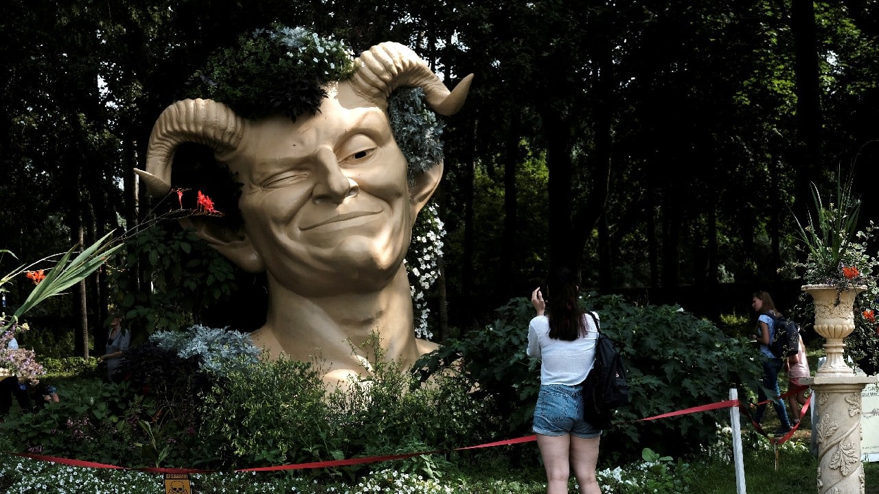 A woman takes a picture of a sculpture depicting servant Puck from Shakespeare's comedy "A Midsummer Night?s Dream" during a flower festival in Pakruojis, Lithuania August 14. (Image: Reuters)