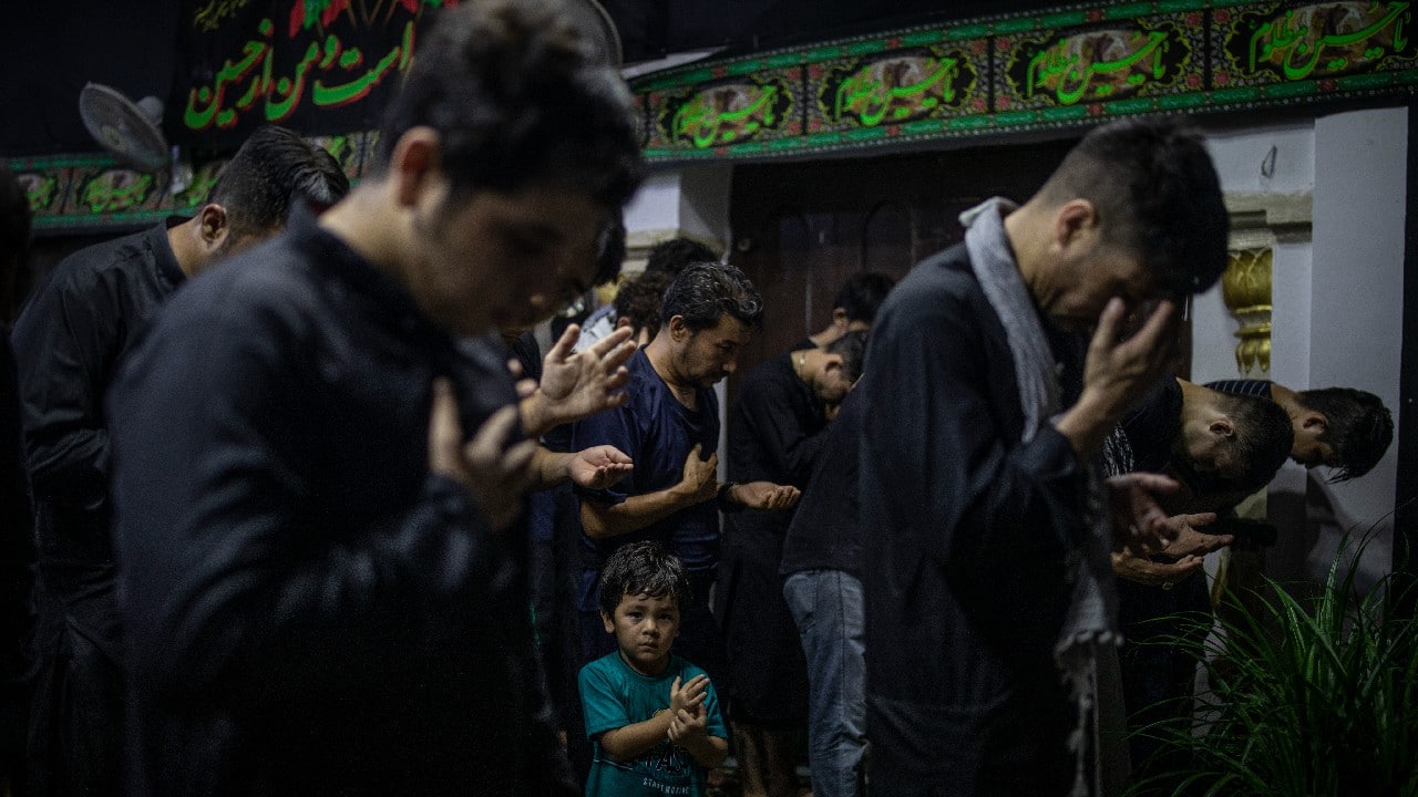 A young boy watches Afghan Shiite Muslim refugees living in India pray during a procession to mark Ashoura in New Delhi, India, August 20. (Image: AP)