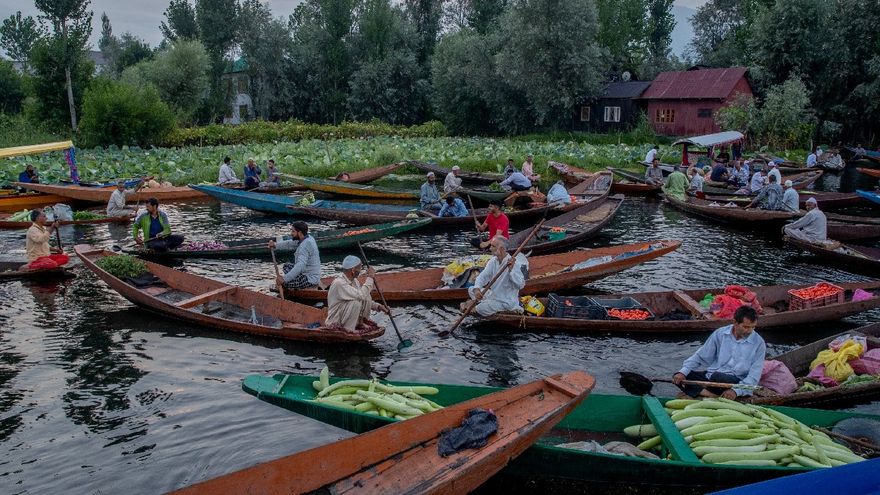 Kashmiri men sell their produce at the floating vegetable market on the Dal Lake in Srinagar, Kashmir. Vegetables traded in this floating market are supplied to Srinagar and many towns across the Kashmir valley. It's one of the major sources of income for the lake dwellers who spend years carefully nurturing their floating gardens from the weed and rich soil extracted from the lake bed. (Image: AP)