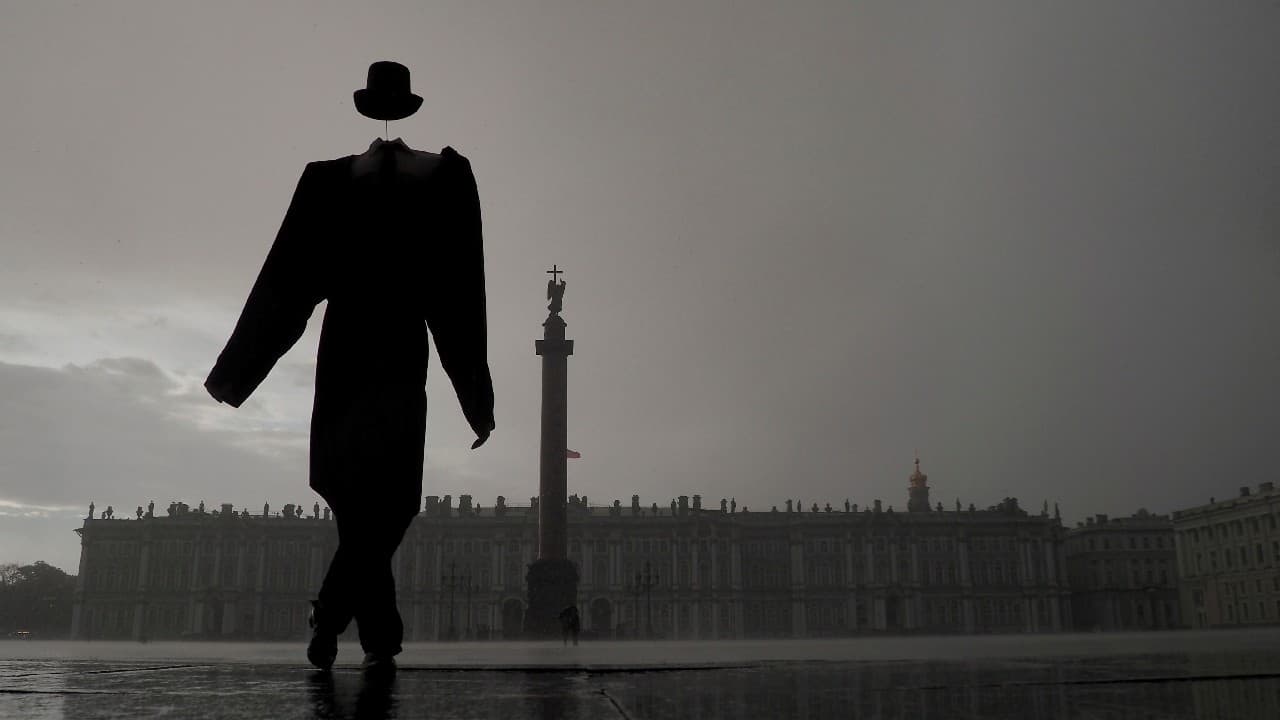 A street performer walks across Palace Square during rainfall in Saint Petersburg, Russia August 15. (Image: Reuters)