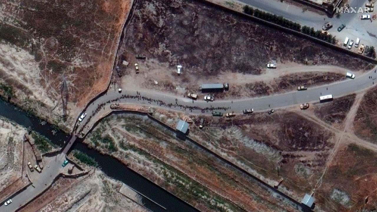 Images shows military plane taxing as people wait on tarmac at Kabul international airport. (Image: Satellite image ©2021 Maxar Technologies/AP)