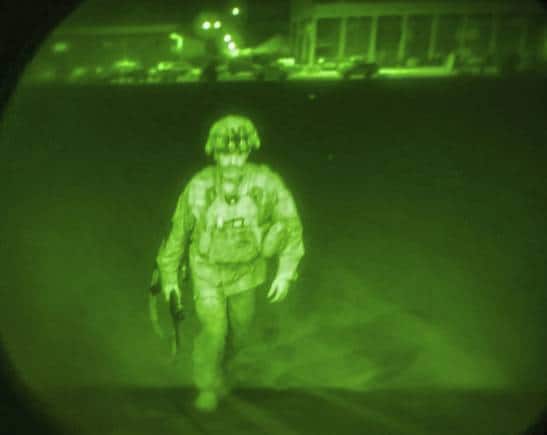 In this image made through a night vision scope and provided by U.S. Central Command, Maj. Gen. Chris Donahue, commander of the U.S. Army 82nd Airborne Division, XVIII Airborne Corps, boards a C-17 cargo plane at the Hamid Karzai International Airport in Kabul, Afghanistan, Monday, Aug. 30, 2021, as the final American service member to depart Afghanistan. (U.S. Central Command via AP)