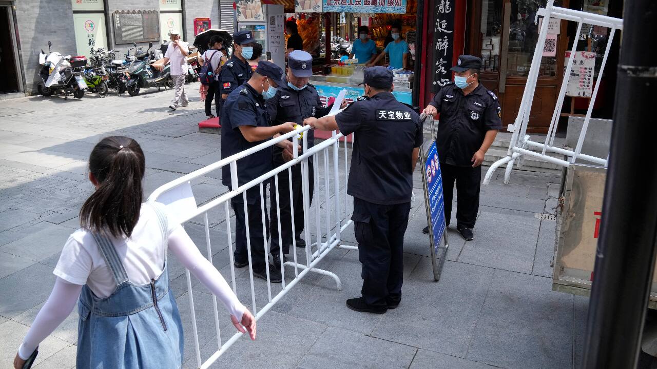 Security officers put up access control barriers along a pedestrian shopping street in a neighborhood popular with tourists in central Beijing. (AP Photo/Mark Schiefelbein)