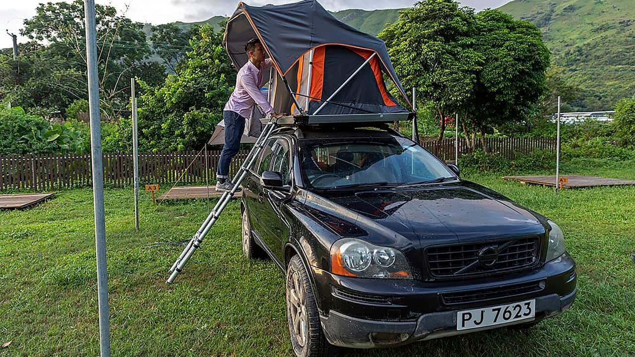 Bill Lau, the founder of local holiday house and yacht booking platform Holimood, checks out a tent in the car camping zone in Hong Kong. (AP Photo/Matthew Cheng)