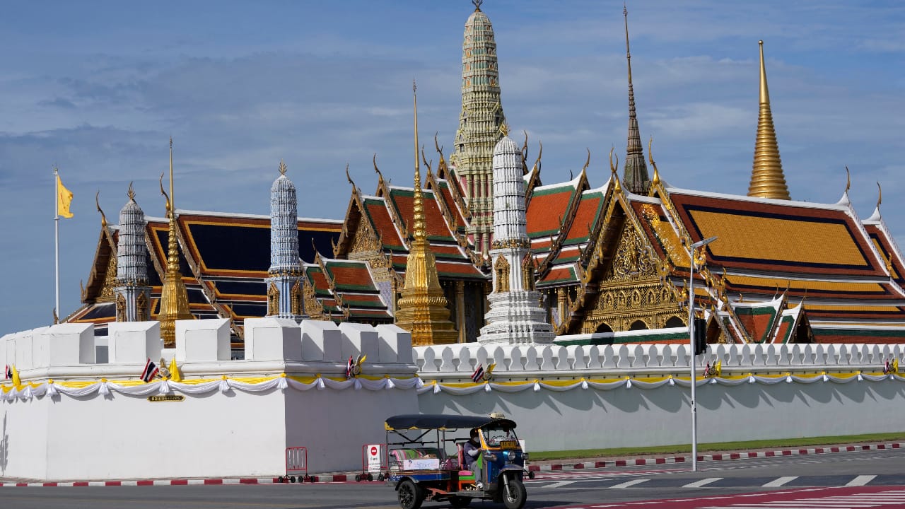 A motor-tricycle, or Tuk Tuk drives past Grand Palace in Bangkok, Thailand. (AP Photo/Sakchai Lalit)