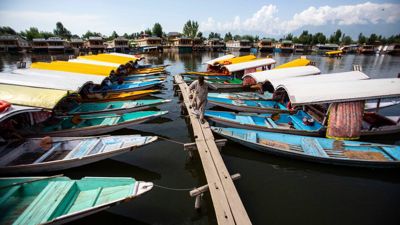 A Kashmiri boatman walks near anchored boats at Srinagar. (AP Photo/Mukhtar Khan)