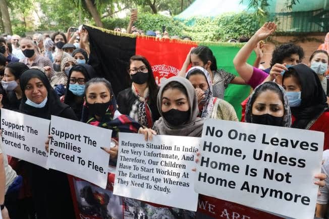 People hold signs as they protest outside the United Nations High Commissioner for Refugees (UNHCR) office to urge the international community to help Afghan refugees, in New Delhi, India, August 23, 2021. REUTERS/Anushree Fadnavis - RC2UAP9DALLM