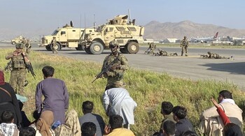 US soldiers stand guard and take a position inside the international airport in Kabul, Afghanistan. Thousands of Afghans have rushed onto the tarmac at the airport, some so desperate to escape the Taliban capture of their country that they held onto the American military jet as it took off and plunged to death. (AP Photo/Shekib Rahmani)