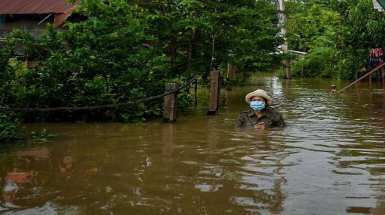A resident wades through floodwaters outside her home in a neighborhood in the central Thai province of Ayutthaya on September 28, 2021, as tropical storm Dianmu caused flooding in 30 provinces across the country. (Image: AFP)