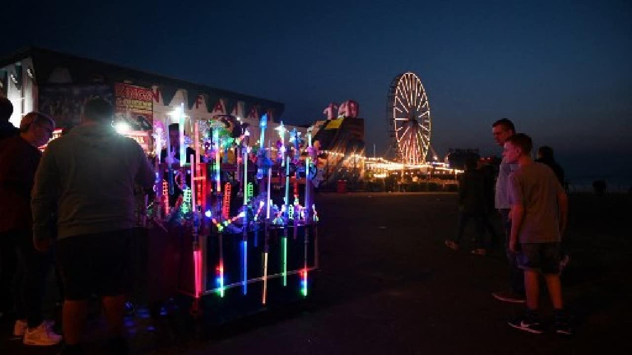 Children clutching glow sticks shrieked with delight and onlookers gazed awestruck as Blackpool's Illuminations lights festival launched to a spectacular volley of fireworks from its 158-metre Victorian tower. The northwest English town's lights display crowns an extended tourist season as Britain's traditional seaside resorts benefit from a domestic tourism boom during the coronavirus pandemic. (Image: AFP) , Domestic tourism boom gives UK seaside new lease of life amid COVID-19 blues, The World Live Breaking News Coverage & Updates IN ENGLISH