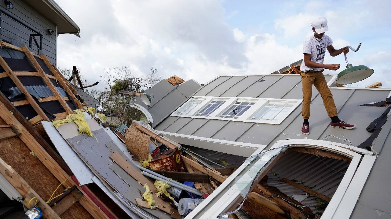 Jeremy Hodges removes a light from his family's destroyed storage unit in the aftermath of Hurricane Ida, August 30, in Houma, La. (Image: AP)