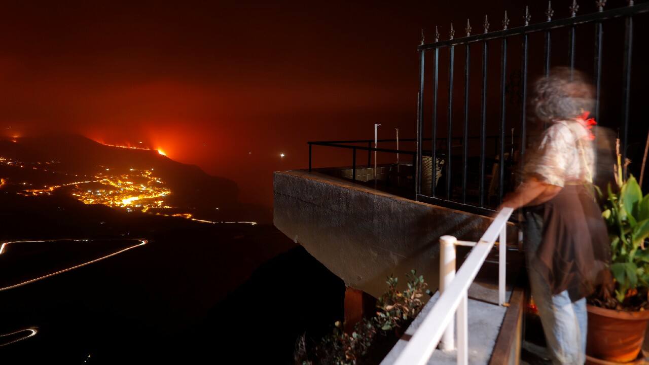 A woman watches from Tijarafe as lava flows into the sea following the eruption of a volcano on the Canary Island of La Palma, Spain. (Image: Reuters) A woman watches from Tijarafe as lava flows into the sea following the eruption of a volcano on the Canary Island of La Palma, Spain. (Image: Reuters)